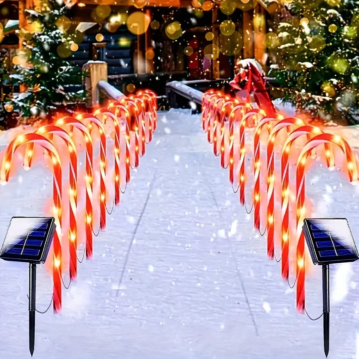 caminho de jardim com bengalas de natal solares acesas na neve