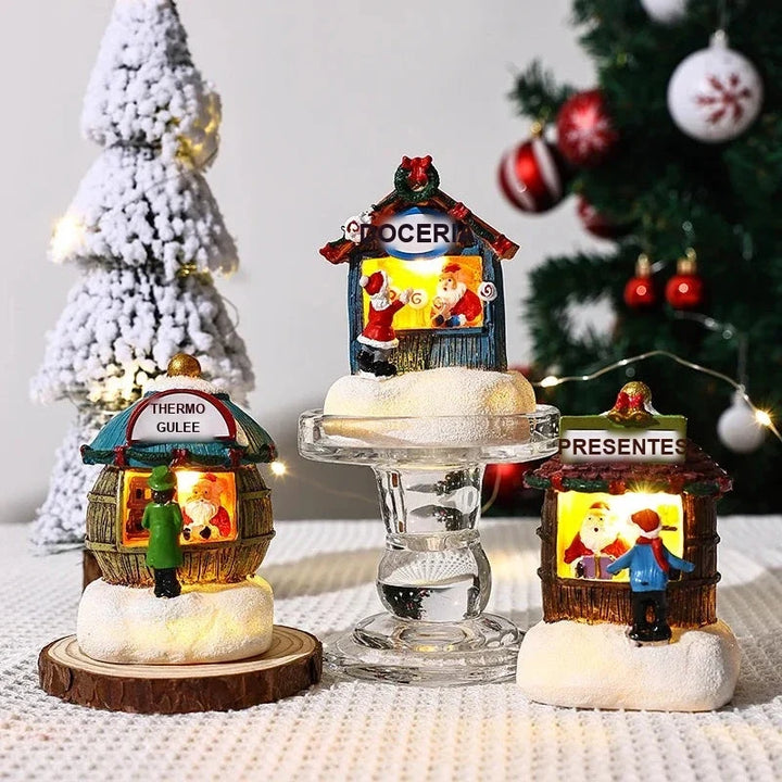 três casinhas de natal em miniatura iluminadas sobre a mesa