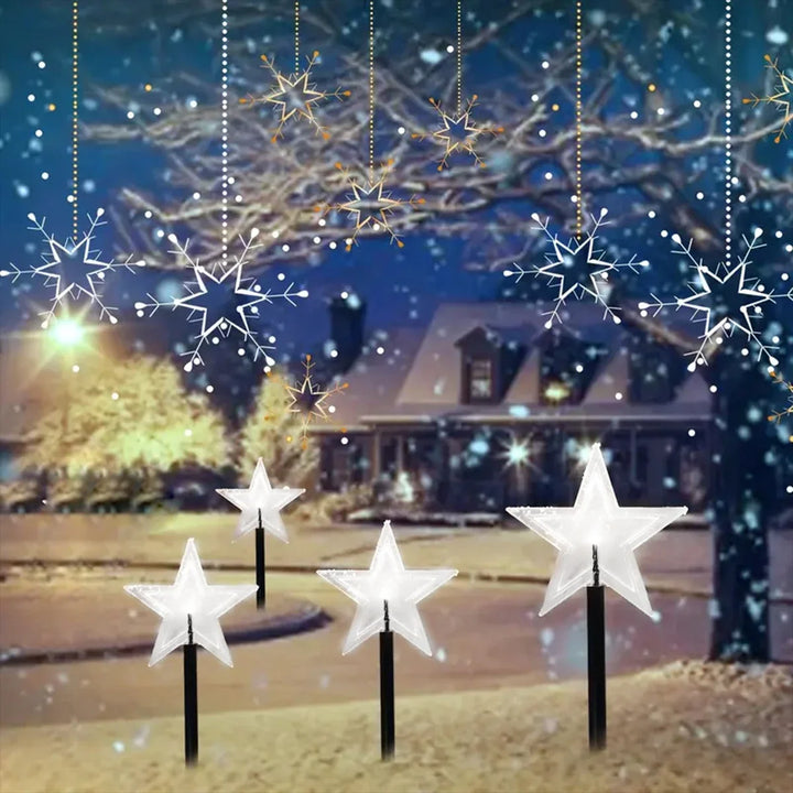 estacas solares de natal em formato de estrela iluminando o jardim