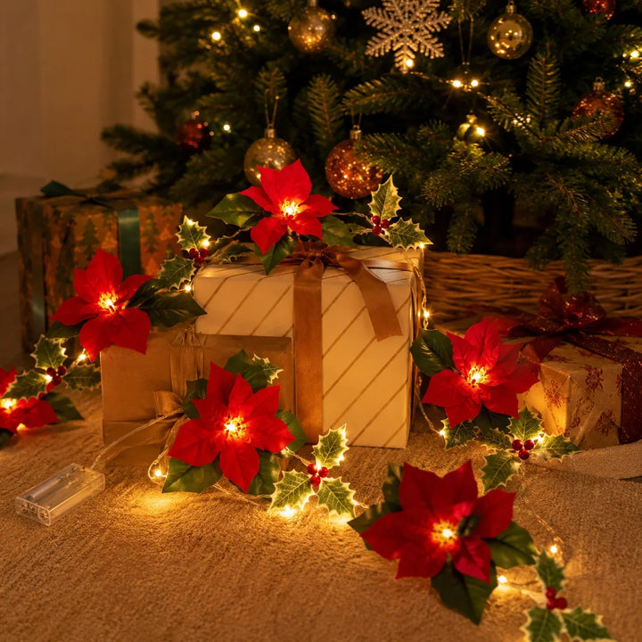 festão de natal com luz entre presentes ao pé da árvore