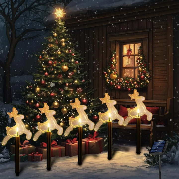 estacas solares de natal formato rena ao lado da árvore de natal