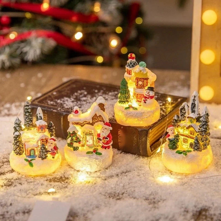 vila de natal com quatro casinhas iluminadas sobre a neve
