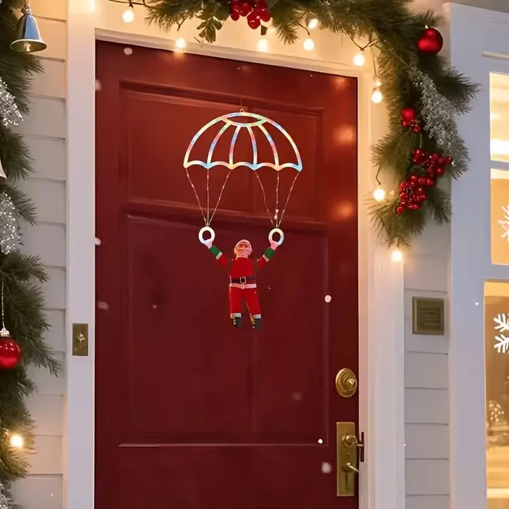 papai noel de paraquedas iluminado pendurado na porta vermelha