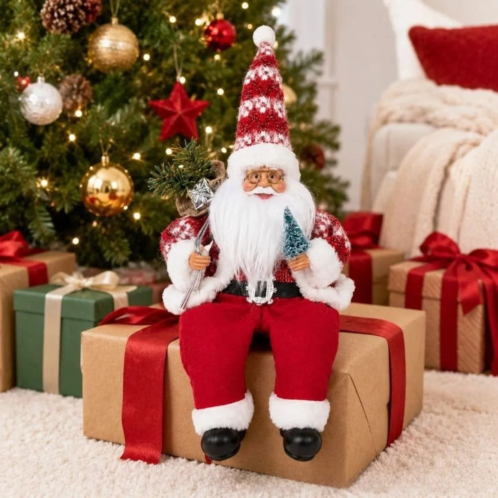 papai noel sentado de tecido sobre presente ao pé da árvore