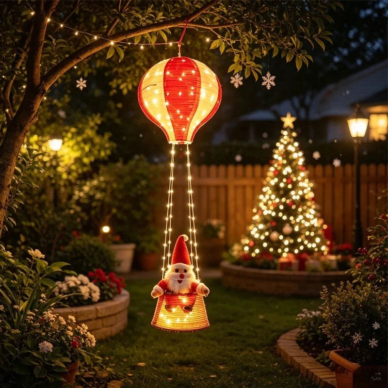 balao de ar quente do papai noel com luz pendurado em arvore do jardim