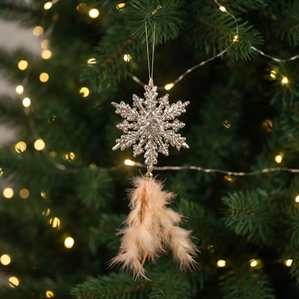enfeite floco de neve dourado com penas na árvore de natal