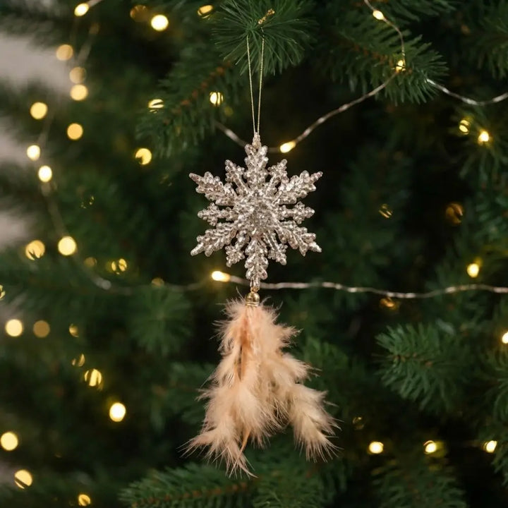 enfeite floco de neve dourado com penas na árvore de natal
