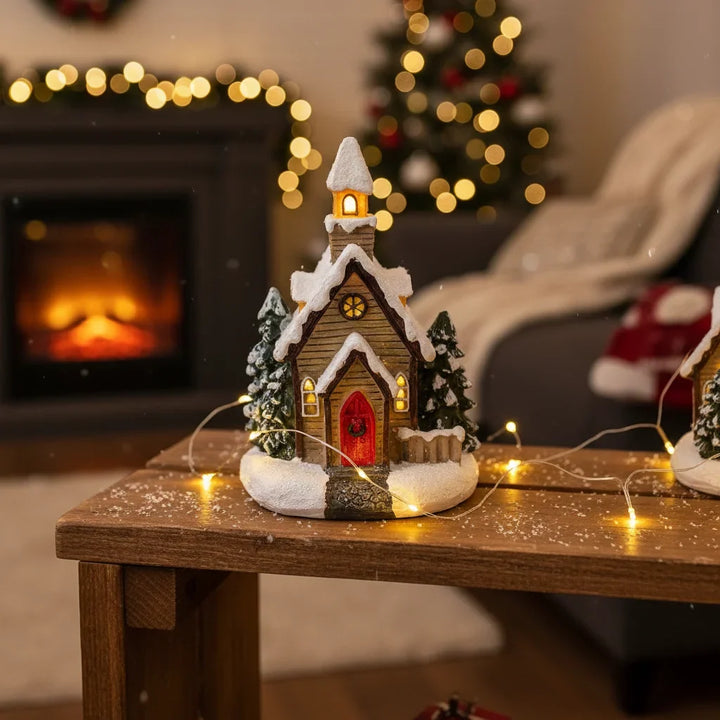 igrejinha de natal iluminada com pisca-pisca na mesa de madeira