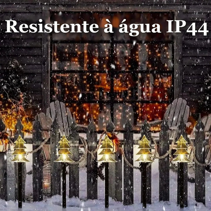 estacas solares de natal formato árvore iluminando cerca do jardim