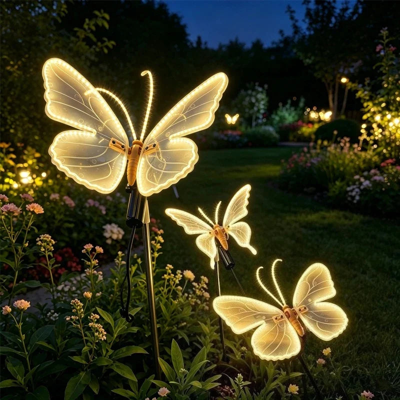 borboletas luminosas de led acesas no jardim florido à noite