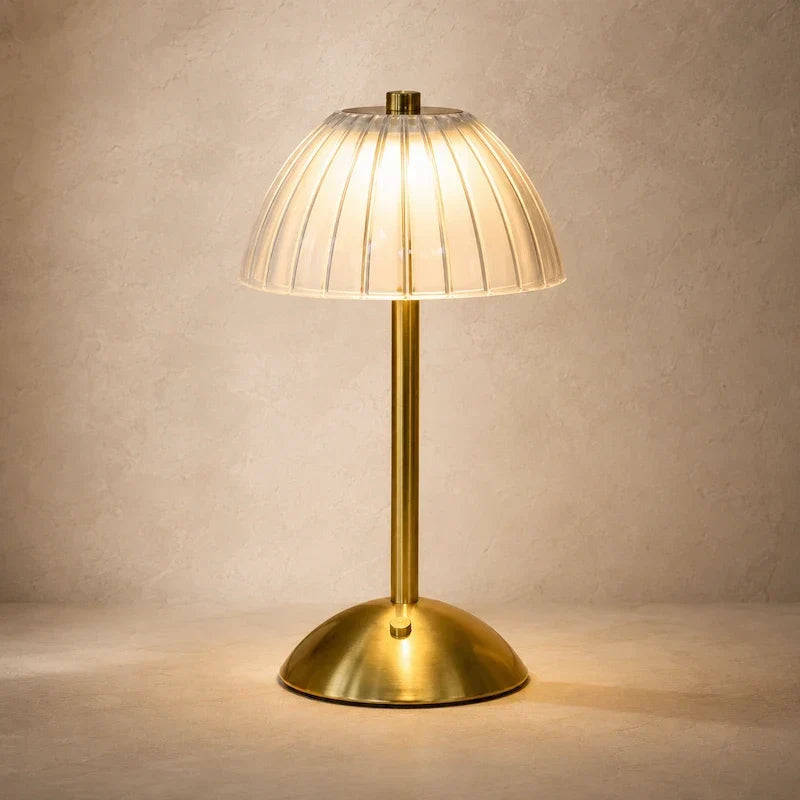 luminária de mesa dourada com cúpula translúcida canelada detalhe do acabamento
