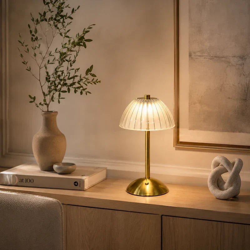 luminária de mesa dourada com cúpula translúcida canelada vista de perto