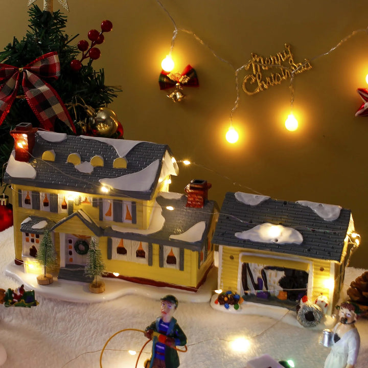 casinha de natal em resina sobre neve artificial com luzes de fada