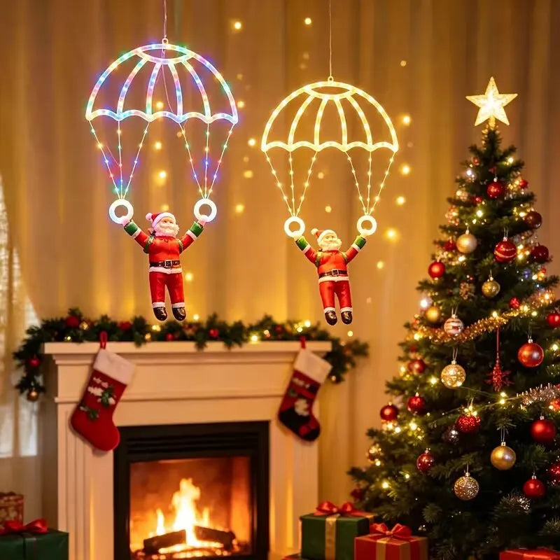 dois papai noel de paraquedas iluminados colorido e branco quente na sala