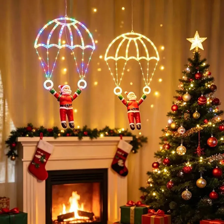 dois papai noel de paraquedas iluminados colorido e branco quente na sala